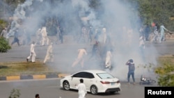 د مې پر ۲۵مه د تحریک انصاف پلویانو د لاریون پر مهال په لاسونو کې کوتکونه نیولي. شنونکي وايي، د هغه ګوند د پلویانو په مظاهرو کې د تاوتریخوالي پېښې کېږي.
