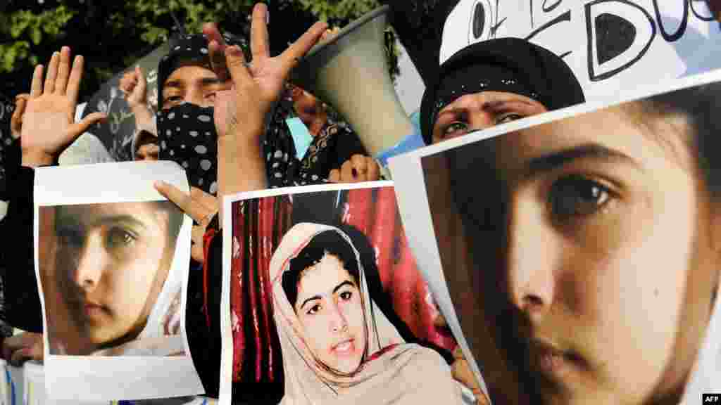 Islamist activists in Lahore carry photographs of Malala during a protest against the assassination attempt.