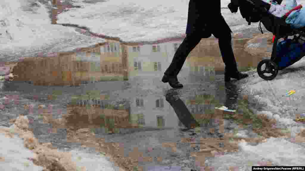 Школа по соседству со станцией метро Дубравная. Лужа прямо на выходе со школьного двора. Мама с коляской привычно огибает лужу по краю и столь же привычным движением заталкивает коляску с ребёнком на вершину снежной горы. 