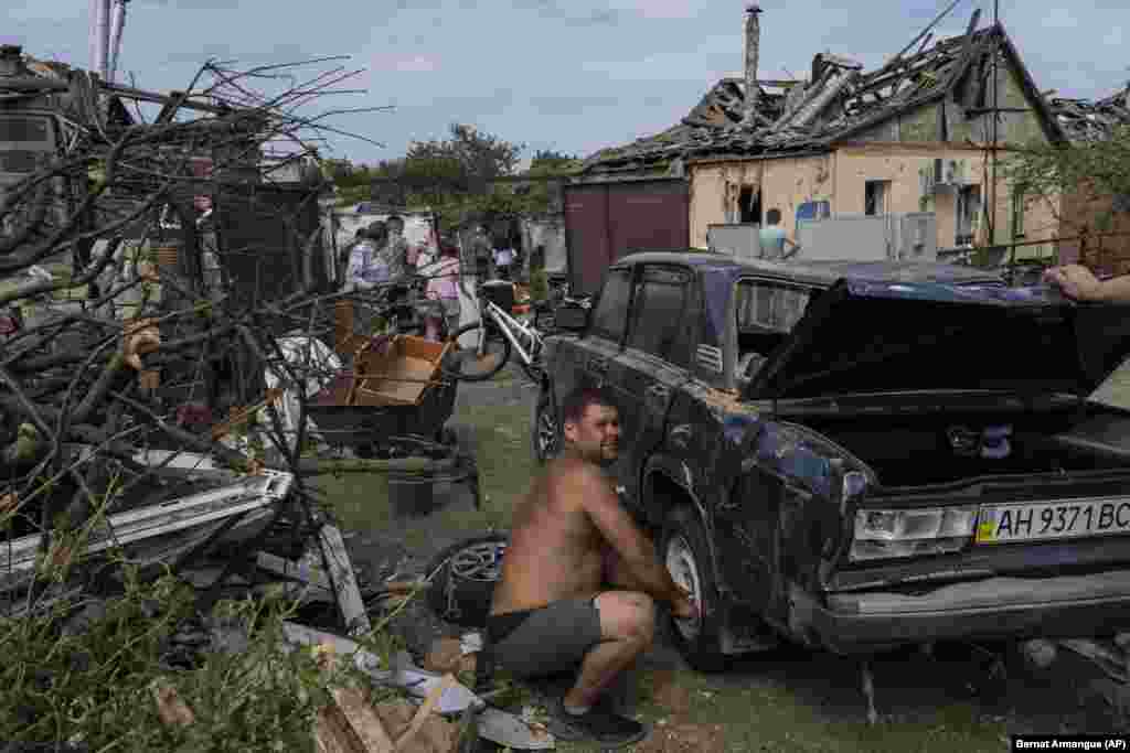 Жители спасают свои вещи из разрушенных домов  