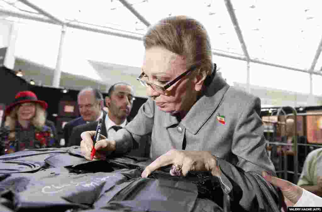 Farah signs an autograph as she visits a contemporary art fair in Monaco in April 2013. 