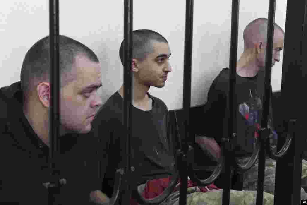 Граждане Великобритании Эйден Эслин и Шон Пиннер и марокканец Брагим Саадун во время так называемого «суда» в оккупированном Донецке 9 июня 2022 года, где группировка «ДНР» вынесла им смертные приговоры  
