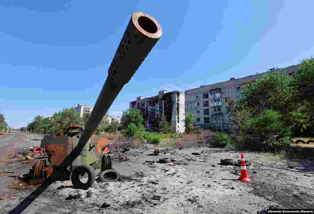 The remains of an MT-12 "Rapira" anti-tank gun near burned-out residential buildings.