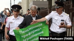 Sergei Mitrokhin (center), head of the Moscow Branch of the liberal opposition Yabloko Party, is detained by police outside the State Duma during a protest against planned pension reform.