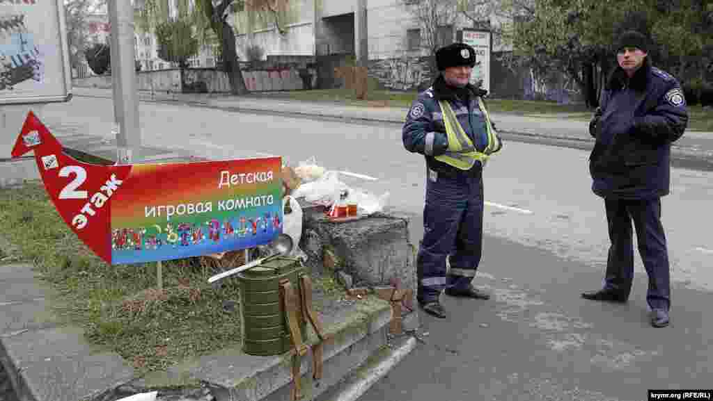 Добросердечные  старушки пытаются угостить милиционеров, дежурящих в оцеплении. Те категорически отказываются и перекусывают развозимым интендантскими службами пайком и супом из армейских ранцевых термосов.