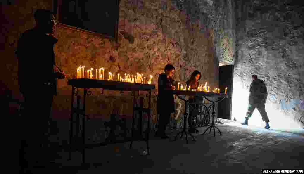 Candles burn inside the monastery on November 12 as a mix of soldiers and civilians arrive to pay their respects. 