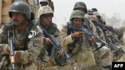 Iraqi soldiers take combat position during a search for insurgents south of Ba'qubah.