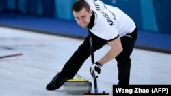 Russia's Aleksandr Krushelnitsky brushes the ice during the curling mixed doubles during the Winter Olympic Games on February 8.