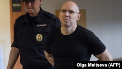 Russian journalist Igor Rudnikov is led to court in Kaliningrad on June 17.