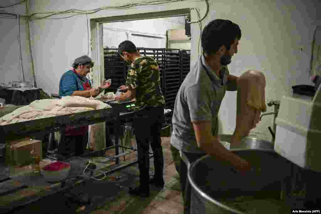 Ghevondian (left) works with colleagues to split the dough into portions before sliding it into an electric oven. The baker's 20-year-old son is currently fighting on the front lines of the battle for Nagorno-Karabakh. She told AFP:  "If my son is there, how could I leave here? I don't ask for anything else. My house can be destroyed, but I want my son near me."  