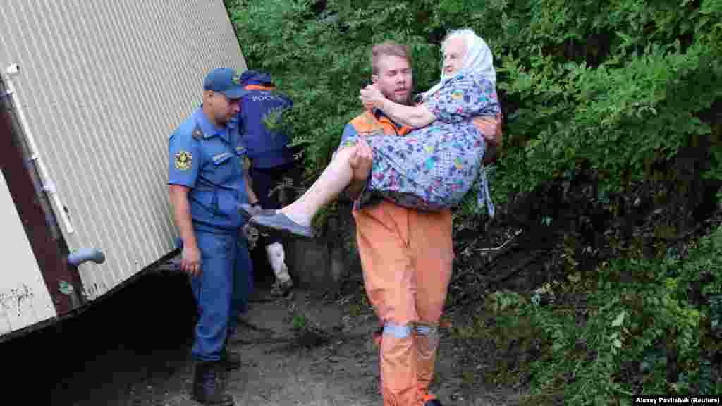 Из всех населенных пунктов Бахчисарайского района поселок Куйбышево во время ливней, которые прошли 4 июля в горах, пострадал больше всего.  На фото: спасатель несет на руках пожилую женщину после затопления