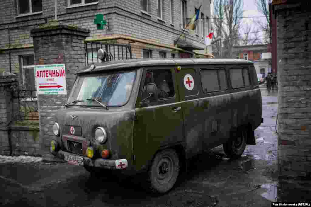 Военный автомобиль скорой помощи выезжает из ворот госпиталя в Артемовске, недалеко от Дебальцева.  
