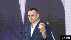 Олег Сенцов передает символическую банку Владимиру Зеленскому