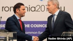 Macedonian Deputy Prime Minister in charge of European Affairs Bujar Osmani (left) shakes hands with Romania's European Affairs Minister George Ciamba in Bucharest on January 28.