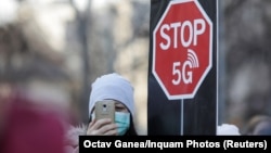 Парадоксы 2020 года: участница акции протеста против технологии 5G в Румынии пользуется мобильной связью, против инноваций в которой выступает