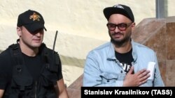 Russian theater and film director Kirill Serebrennikov (right), is escorted outside Moscow's Basmanny district court after a hearing on August 12.