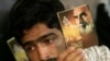 A man in 2007 holds a portrait of Ayatollah Ruhollah Khomeini during a memorial ceremony to mark the 18th anniversary of Khomeini's death at his mausoleum in Tehran.
