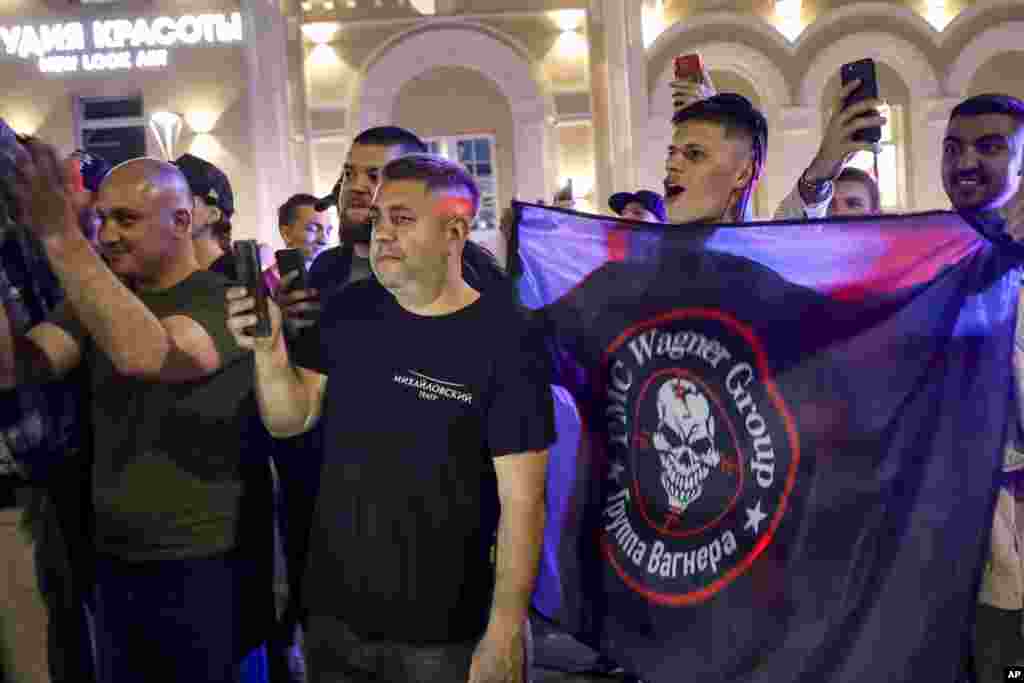 Люди аплодируют и машут флагом ЧВК «Вагнер» возле военного штаба в Ростове-на-Дону. Кремль заявил, что Александр Лукашенко из Беларуси помог в заключении сделки с Пригожиным. Пресс-секретарь Кремля Дмитрий Песков сообщил, что Путин и Лукашенко гарантировали безопасность владельца ЧВК  