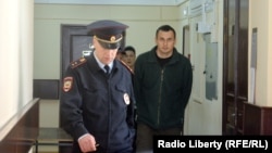 Олег Сенцов в сопровождении охраны