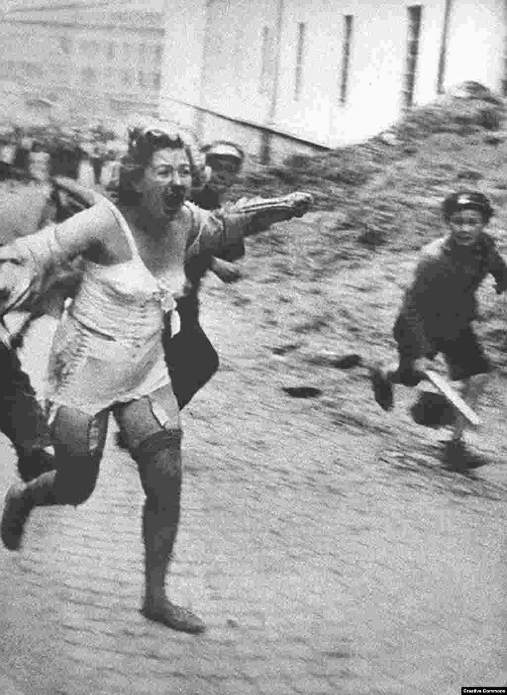 Еврейка убегает от толпы во Львове. Город в межвоенное время был польским, затем оккупирован СССР и в конце – нацистами. Фото сделано в июне или июле 1941 года. При активном поощрении нацистов евреи советской Украины и других оккупированных территорий переживали настоящий ужас. Тысячи из них были замучены и убиты в результате погромов, устроенных в Центральной и Восточной Европе.