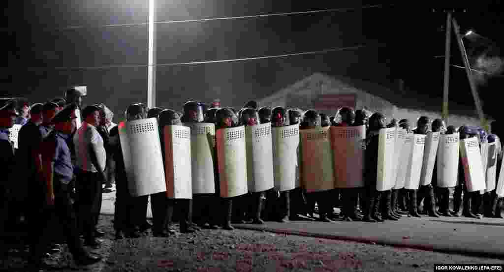 Riot police in formation during the raid. The authorities have since withdrawn from the village. 