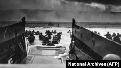 Американские солдаты высаживаются на пляже «Омаха» в Нормандии. 6 июня 1944 года.