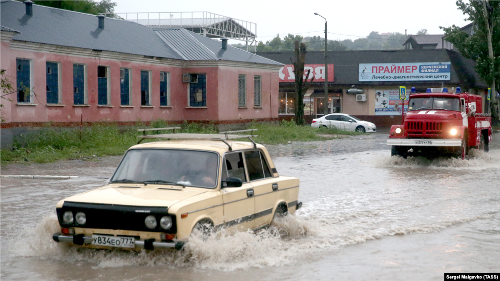 Пожарный автомобиль на подтопленной улице в результате ливневых дождей 