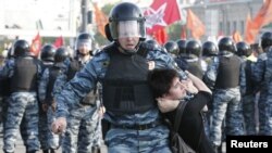 A riot police office detains a female protester during an opposition protest in Moscow's Bolotnaya Square in May 2012.