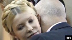 Yulia Tymoshenko is embraced by her husband Oleksandr after her conviction is announced.