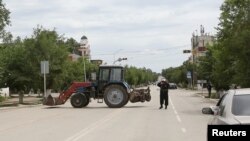 A Kazakh police officer blocks a street near the site of an exchange of fire between security forces and suspected militants linked to deadly attacks this week in Aqtobe.