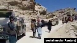 یو شمېر خلک پنجشېر ته نېږدې په ګلبهار سیمه کې د طالبانو له ګاډو سره ولاړ دي. د ۲۰۲۱ز کال د سېپټېمبر څلورمې انځور.