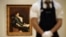 Сотрудник аукциона Sotheby's перед выставленной на торги картиной кисти Ильи Репина "Портрет жены художника". Лондон, 2011 год