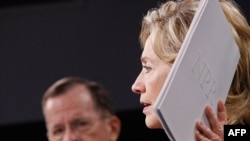 U.S. Secretary of State Hillary Clinton holds up a copy of the Nuclear Posture Review during a news conference with Chairman of the Joint Chiefs of Staff Mike Mullen