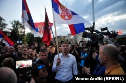 Bosko Obradovic flutură un steag sârb în timpul protestelor din Belgrad, în 2020.