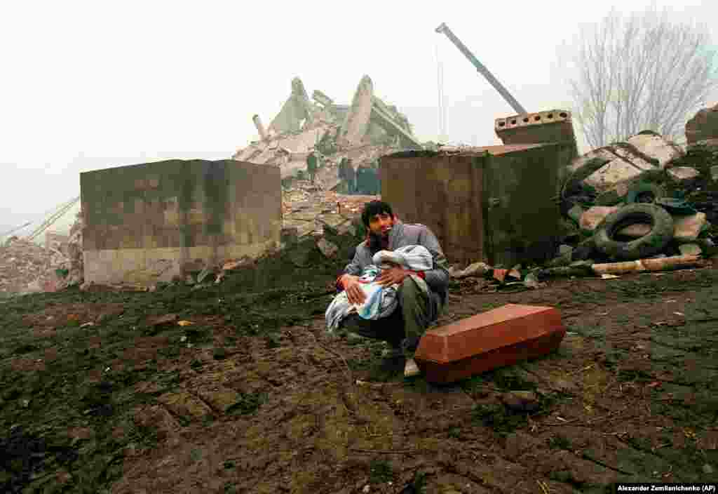 A man holds the body of his dead child in Gyumri. The quake lasted just 20 seconds, with a magnitude of 6.8, but the dust cleared to scenes of utter devastation. 
