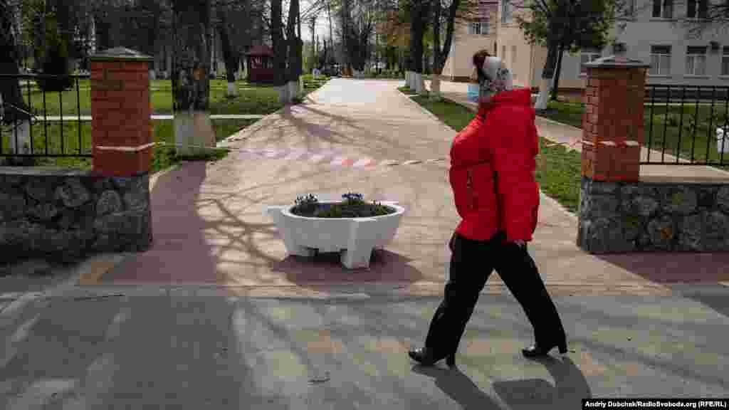 Женщина проходит мимо больницы в Калиновке. Доступ в медицинское учреждение ограничен.  В Калиновке проживает около 20 тысяч жителей. Улицы в основном пусты, полицейские патрулируют город и из громкоговорителей призывают местных не выходить из дома  