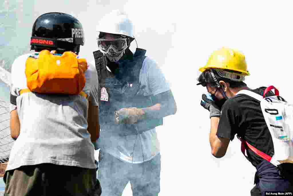 Протестующие защищаются от слезоточивого газа. Янгона, 28 февраля 