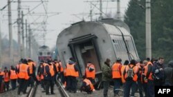 Workers prepare to remove a derailed car of the Nevsky Express.