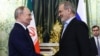 Russian President Vladimir Putin (left) and Iranian President Masud Pezeshkian shake hands during a meeting at the Kremlin in Moscow on January 17, 2025.