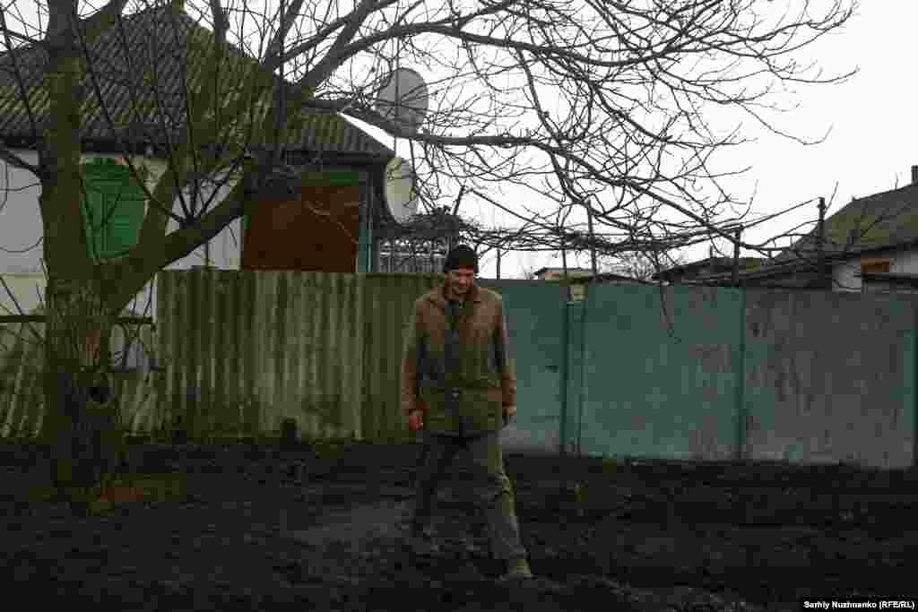 Un locuitor al satului Ternî lângă casa sa, în martie 2023. Luptele pentru satul grav avariat au început în ianuarie 2023. La începutul acestui an, satul era ocupat în totalitate. 