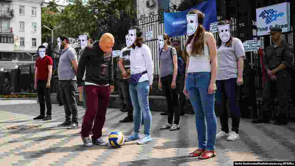 В этот раз активисты наглядно показали, как «президент России играет сердцами и захватывает людей». Условный Путин начал «играть с человеческими жизнями», которые неподвижно стояли у входа у посольство