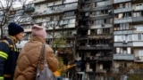Психолог службы спасения разговаривает с жительницей, осматривая ее жилой дом, который был поврежден в результате ночного удара российского беспилотника, Киев, Украина, 26 октября 2025 года. REUTERS/Valentyn Ogirenko