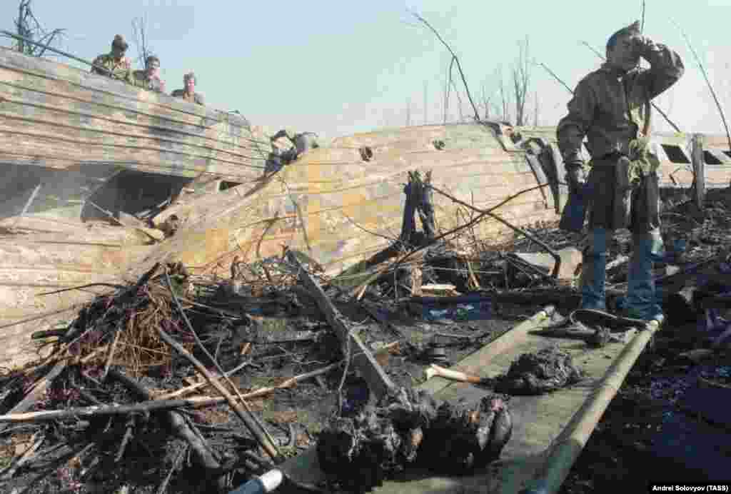 Советский военнослужащий не может сдержать слез при виде обгоревших человеческих останков.  