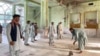 Afghan men inspect the damage at a Shi'ite mosque in Kandahar on October 15 after a suicide bombing during Friday Prayers.