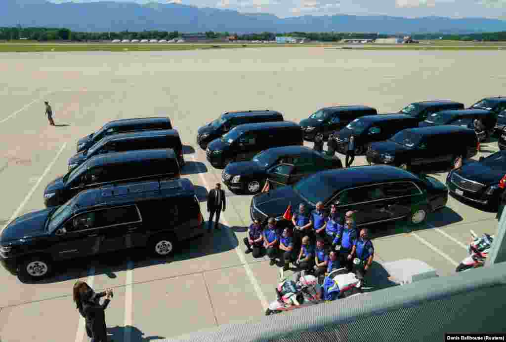Geneva police pose for a photo next to a motorcade as they await the arrival of President Biden at Cointrin Airport on June 15. 