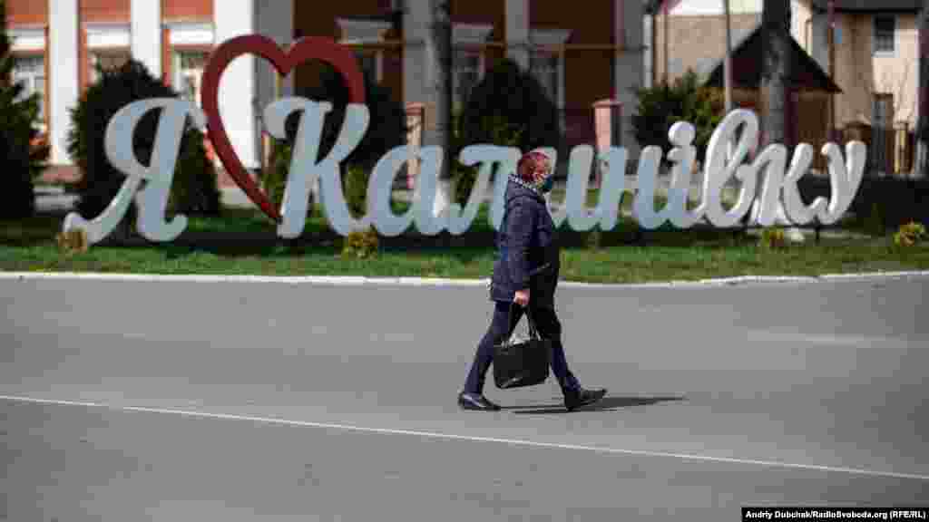 Женщина проходит мимо знака с надписью «Я люблю Калиновку»  