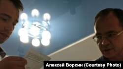 Сотрудник военкомата вручает кандидату в мэры Хабаровска Алексею Ворсину повестку