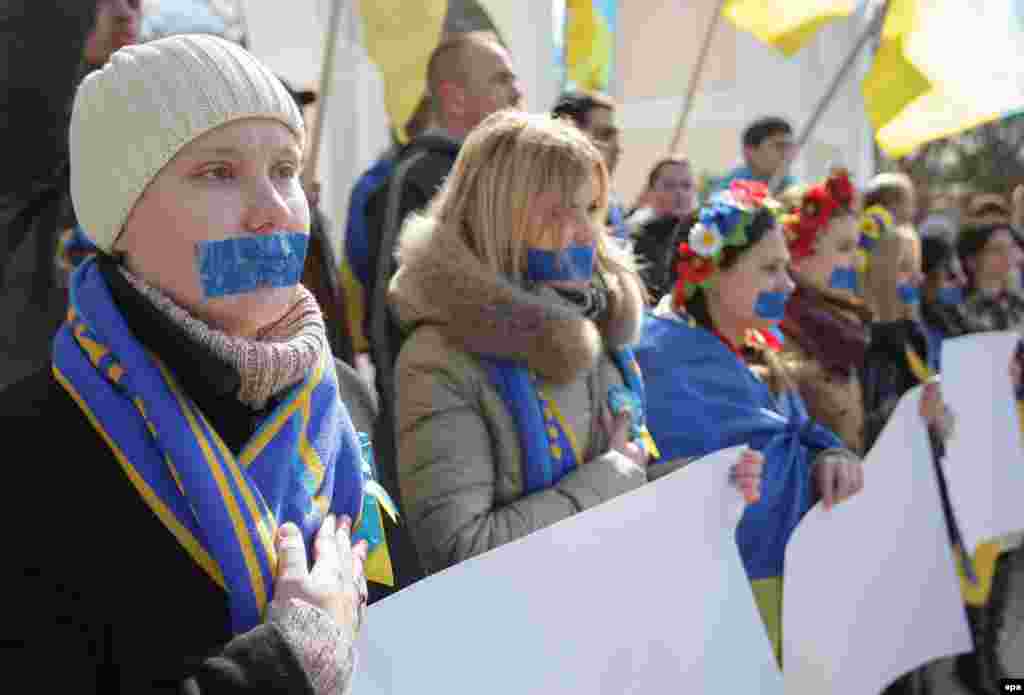 Участницы акции, представительницы движения «Женщины Крыма за МИР», провели в Симферополе молчаливую акцию в поддержку свободы слова. Девушки заклеили себе рты синей лентой, а в руках держали чистые плакаты без единой буквы. 13 марта 