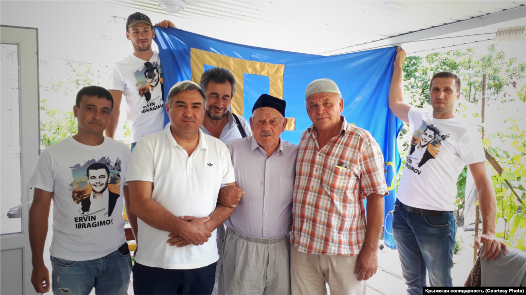 Июнь 2020. Крымскотатарские активисты в гостях у ветерана национального движения Джеппара Абдуджемилева. Их визит – часть марафона, приуроченного ко дню флага. Акция стартовала 24 июня и за эти несколько дней ее участники планировали объездить с крымскотатарским флагом весь Крым, попутно наведываясь к ветеранам. В финале же флаг подняли на скалу Ак-Кая (Белая скала) в Белогорском районе