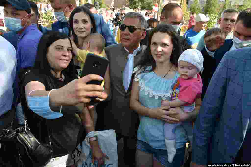 Впрочем, в перерыве между селфи Рустам Минниханов успевает произнести со сцены речь, в которой призывает многочисленных собравшихся: "Очень прошу вас соблюдать социальную дистанцию — конечно, мы устали от масок, от перчаток... Но придётся немножко беречь себя". 